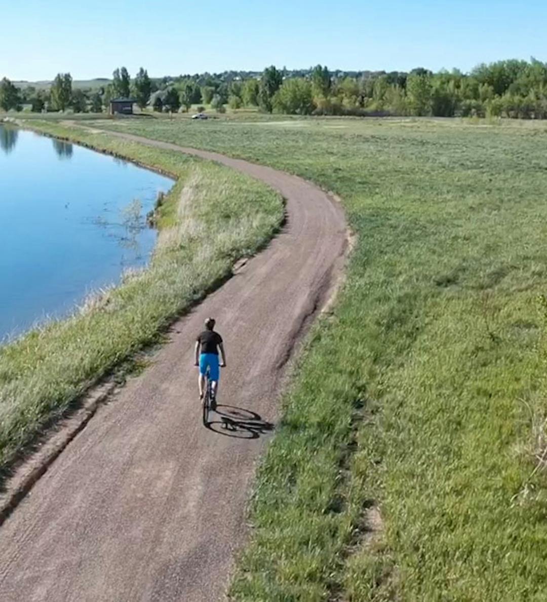 The image shows a man biking on Kyger trail