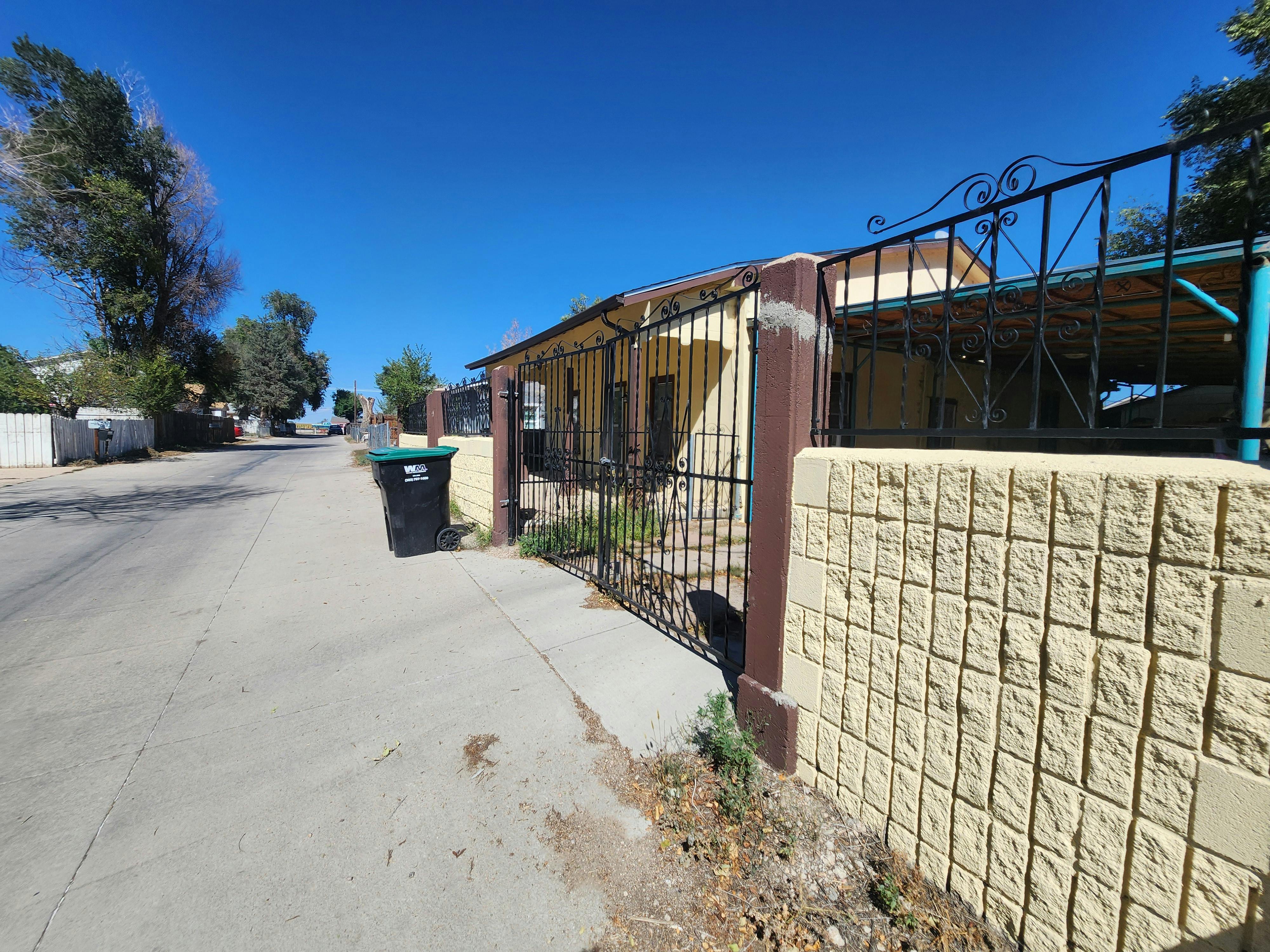 Spanish Colony street with property wall and gates along the street.