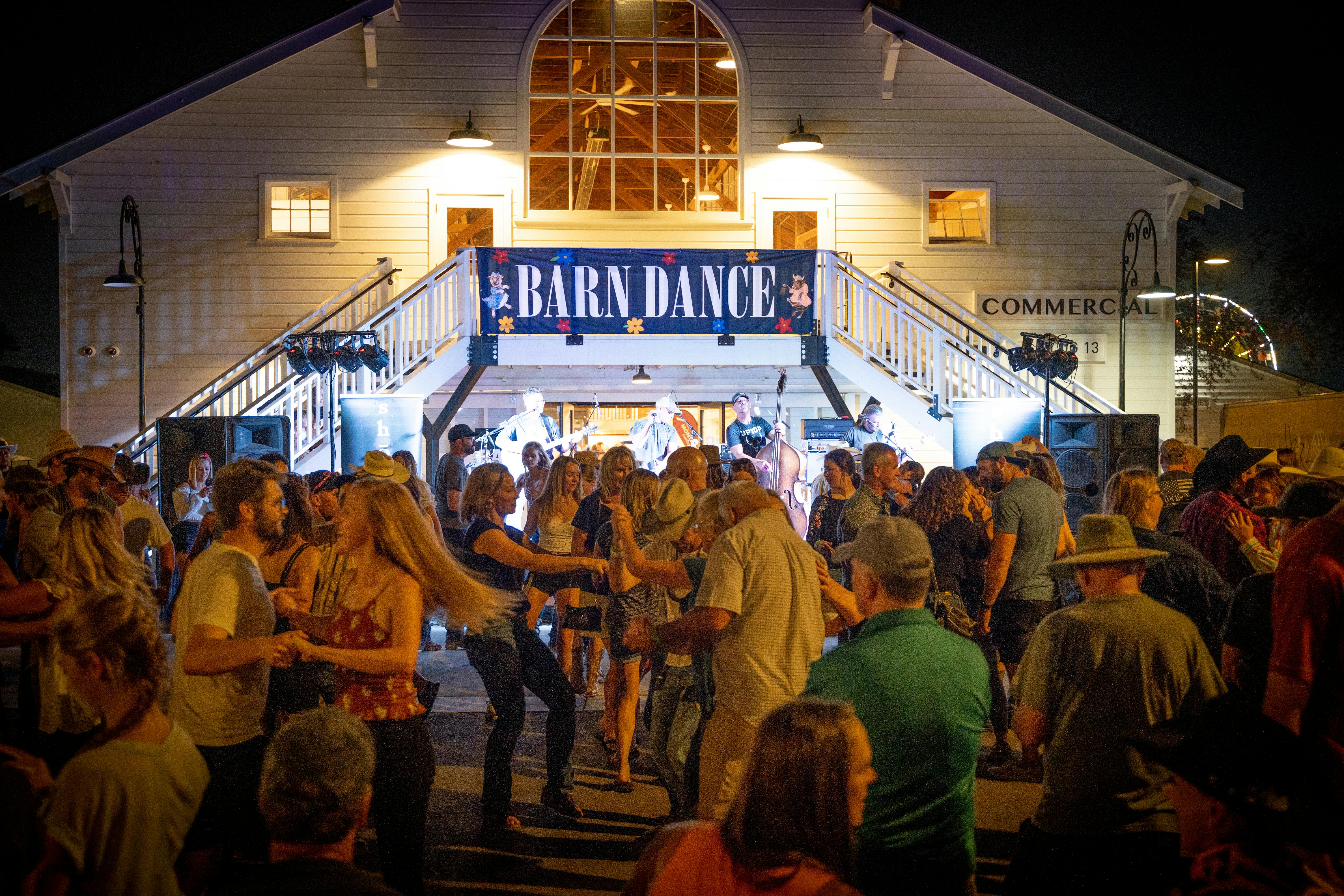 A photo of a lively barn dance in front of the Commercial Building at night.