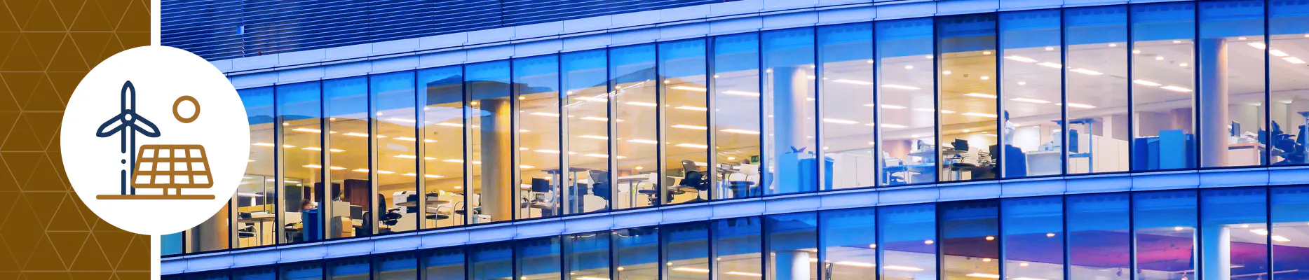 An office building with workers, computers and lights shining.