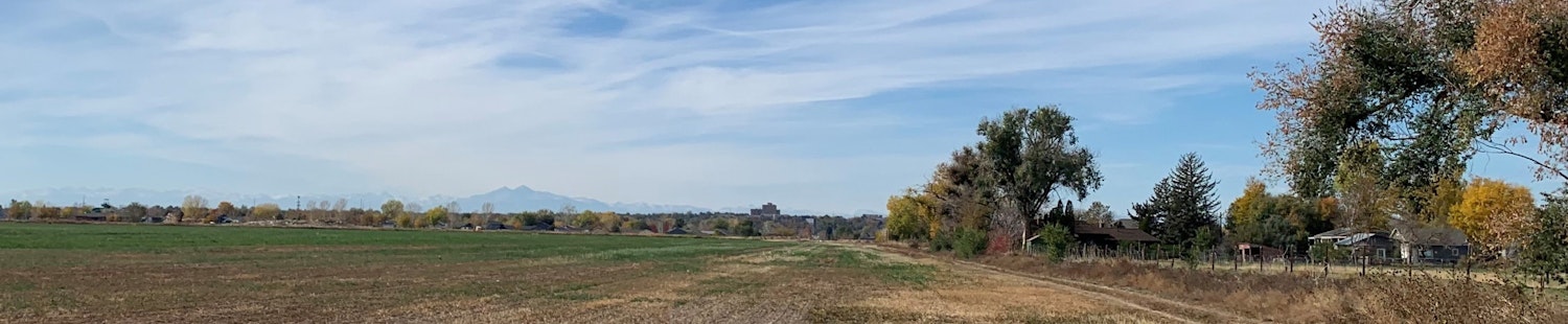 Looking west towards Greeley with agriculture land in the foreground and the city in the background at sunset.