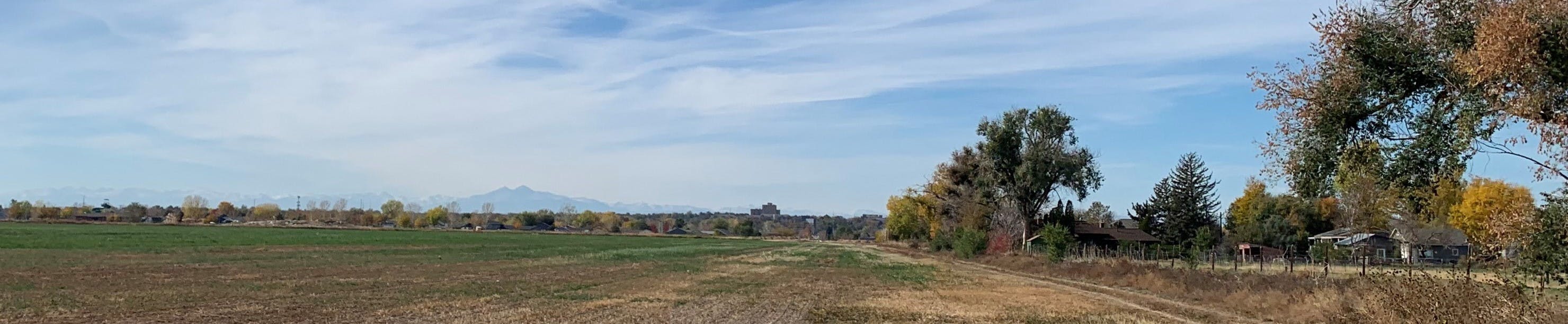 Looking west towards Greeley with agriculture land in the foreground and the city in the background at sunset.
