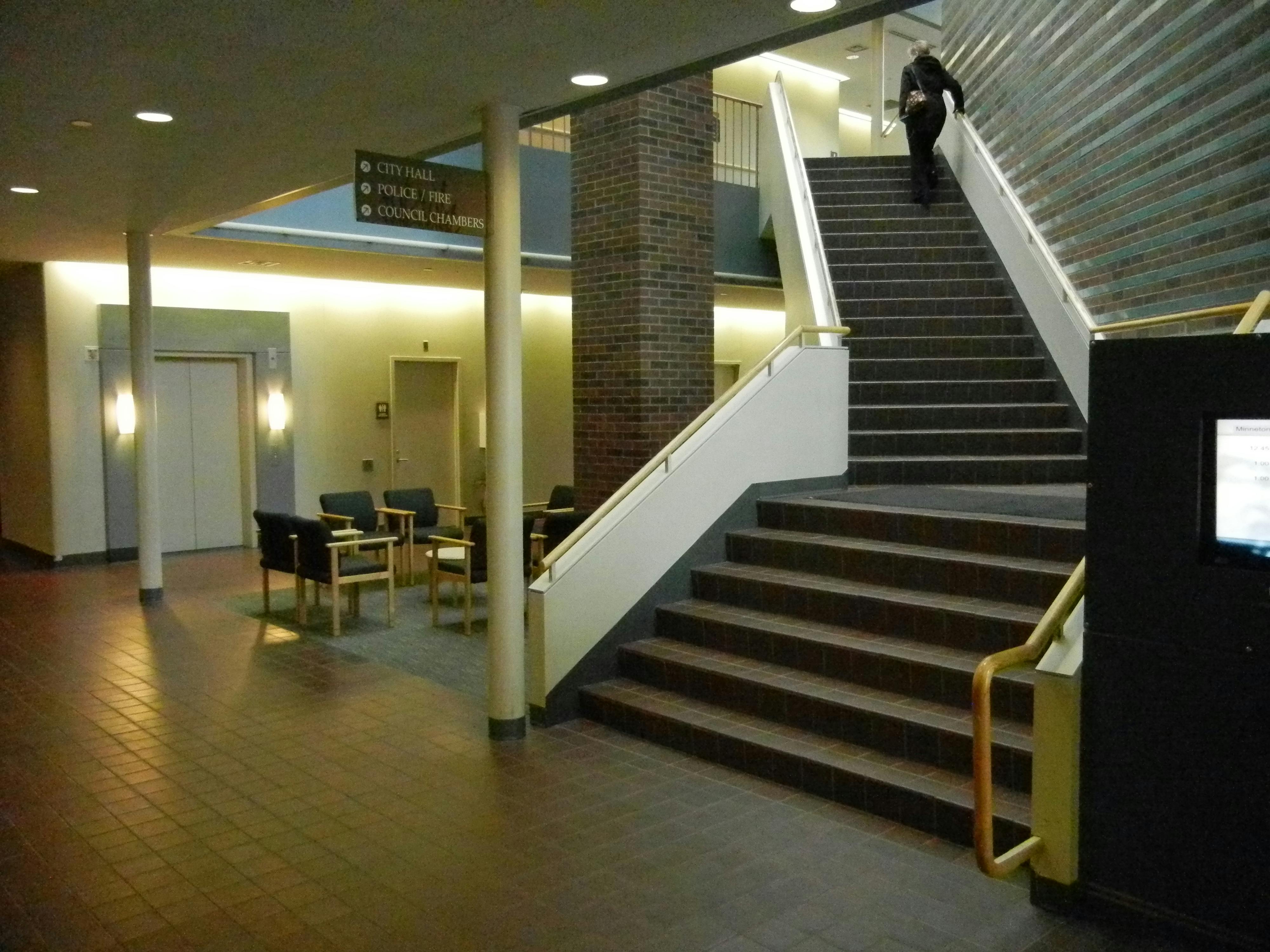 The interior of a community center with a stairwell leading to an upper floor.