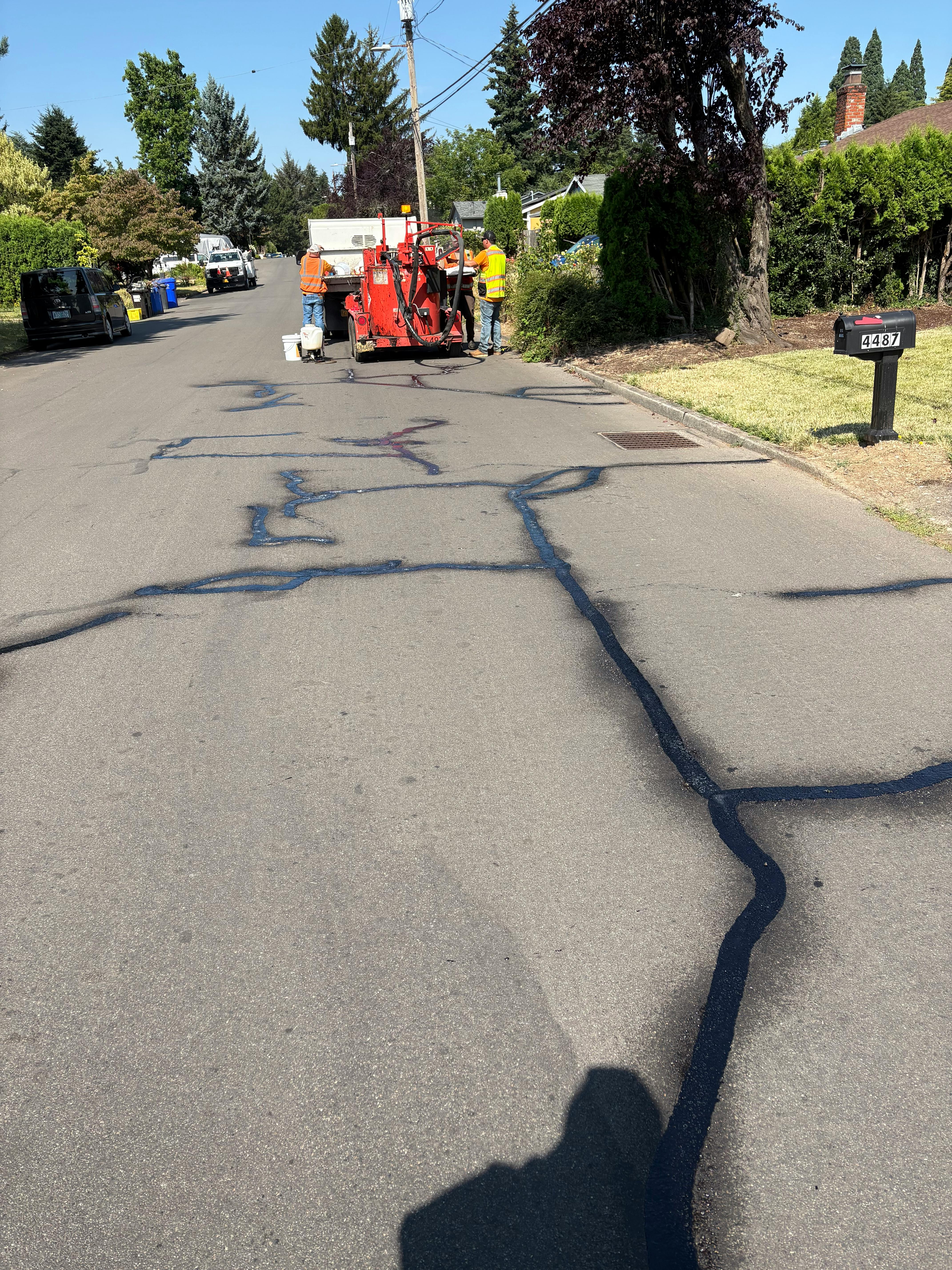 Public Works Filling Cracks in Road with Sealant
