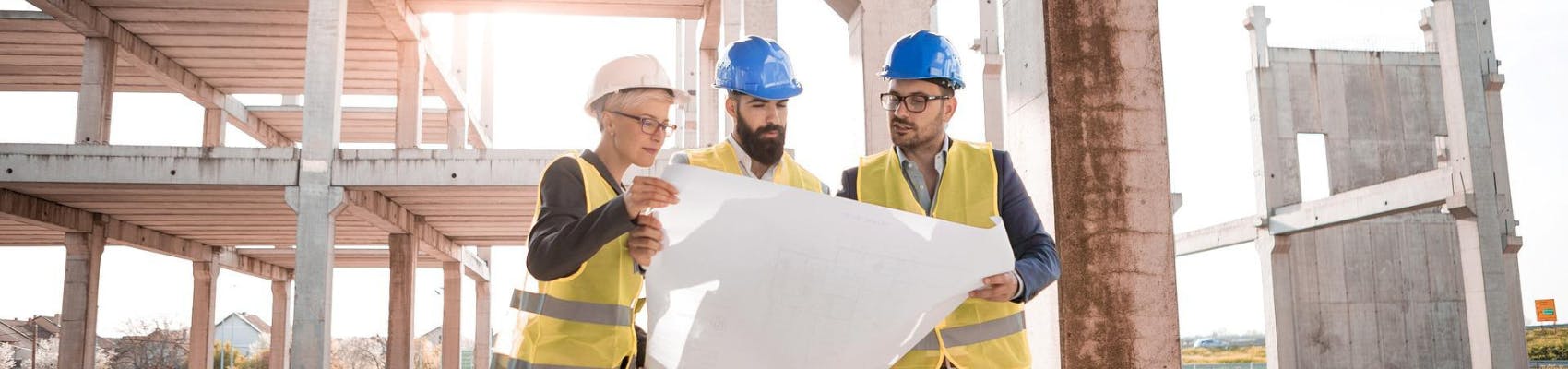 Stock image of construction workers looking at plans