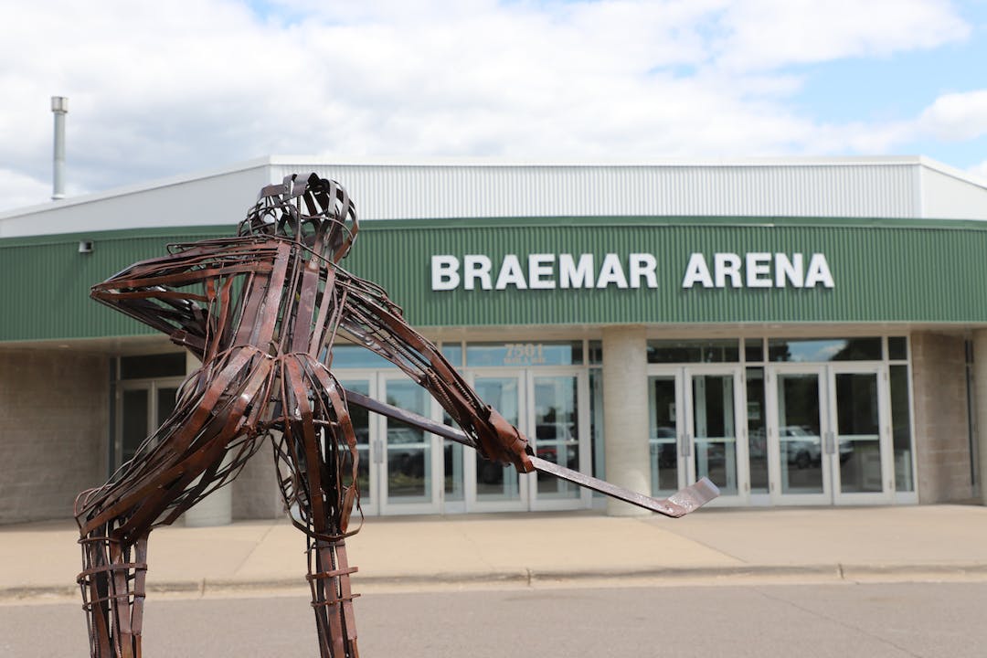 Front entrance of Braemar Arena with metal sculpture of hockey player in foreground