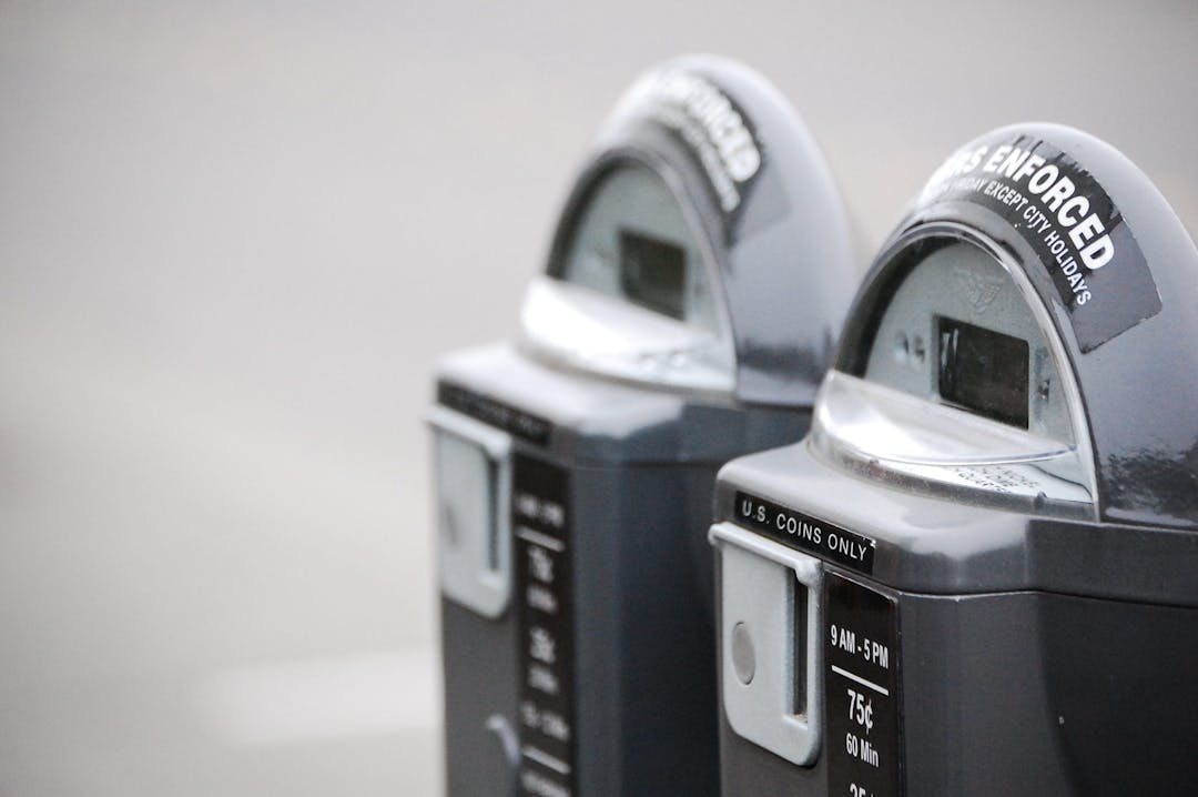 close up of two metal coin operated parking meter