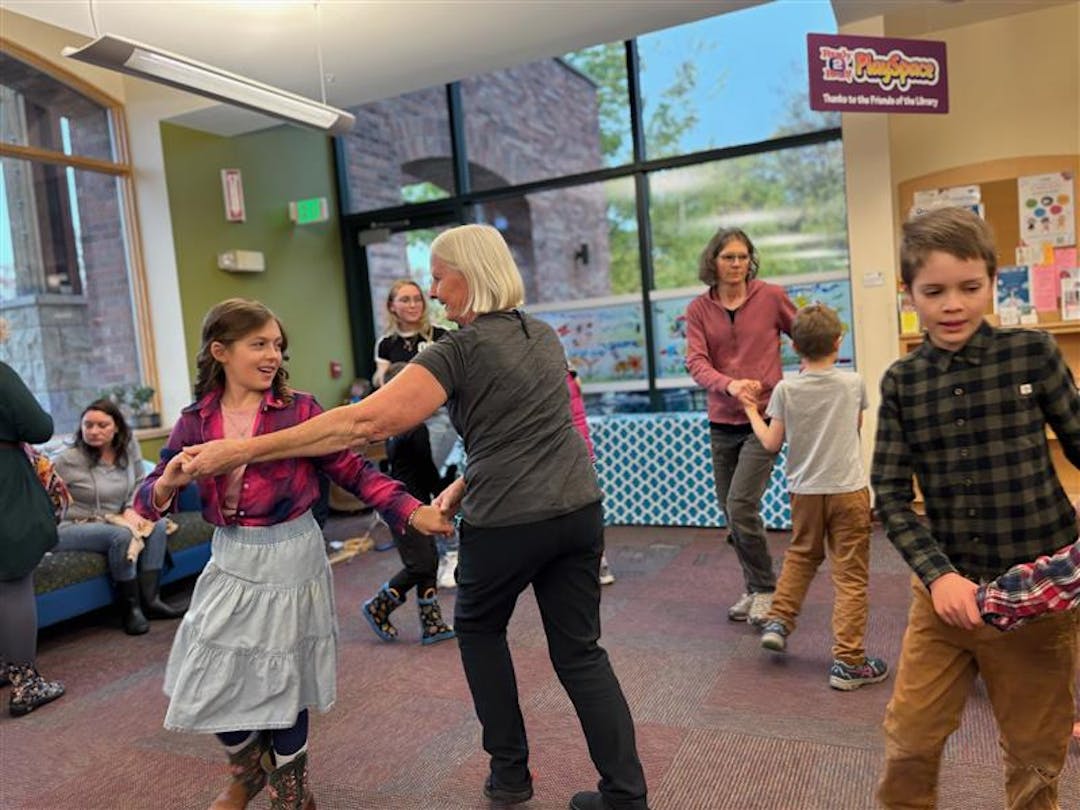 Children and adults dancing in a room 