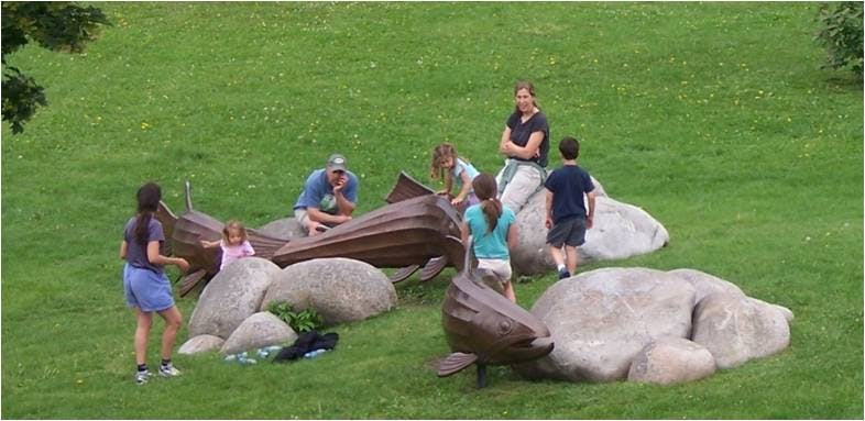 Family play on the sculpture "Returnings" in East Caras Park
