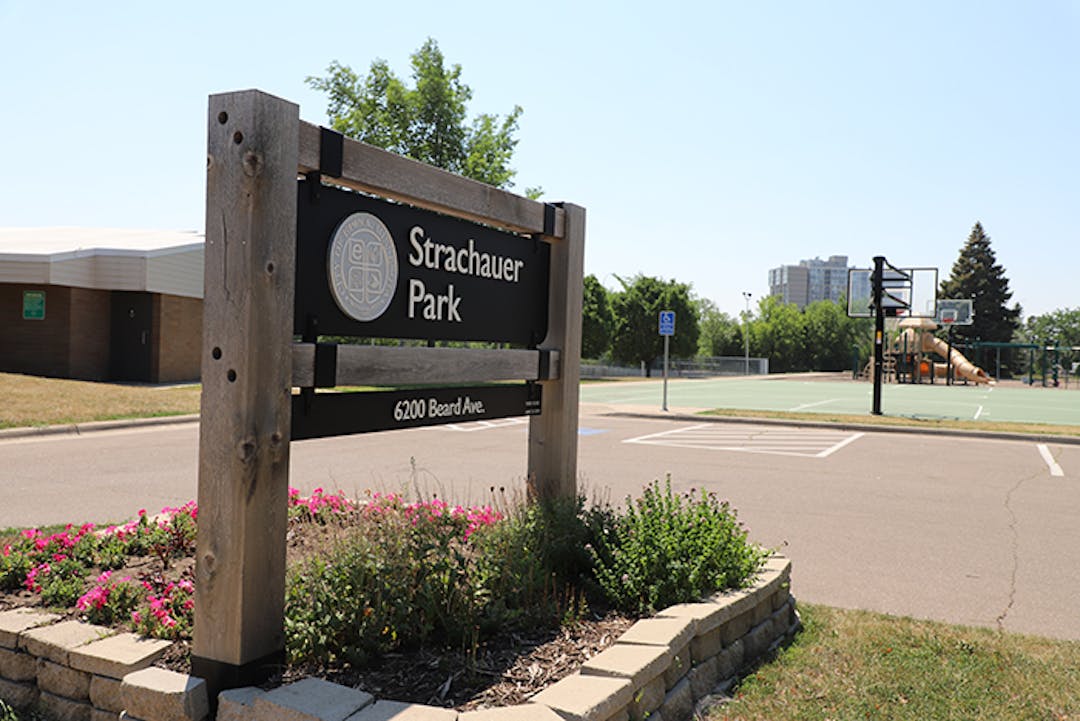 Strachauer Park sign with shelter building and basketball court in background