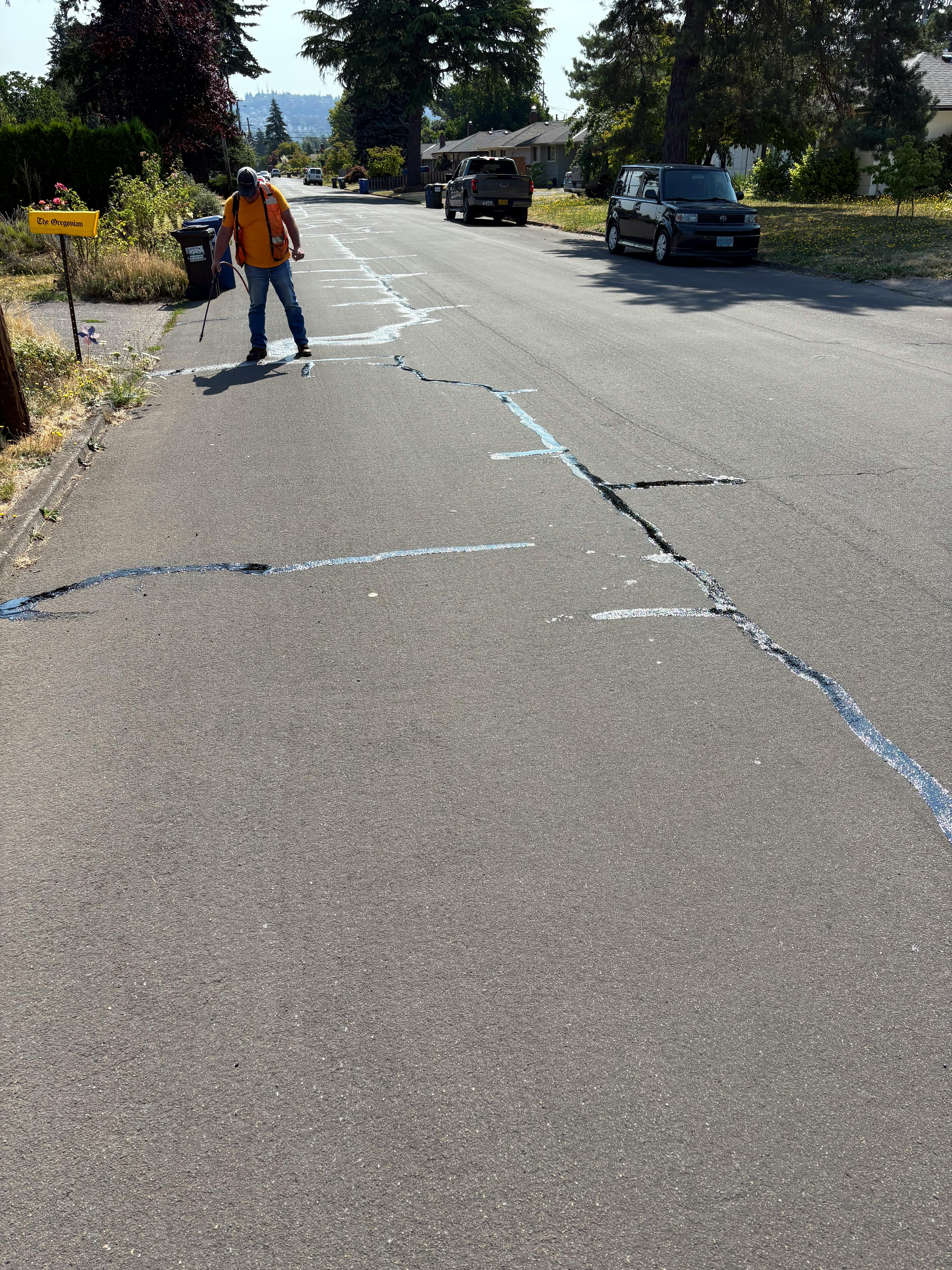 Public Works Staff Filling Cracks in Road with Sealant
