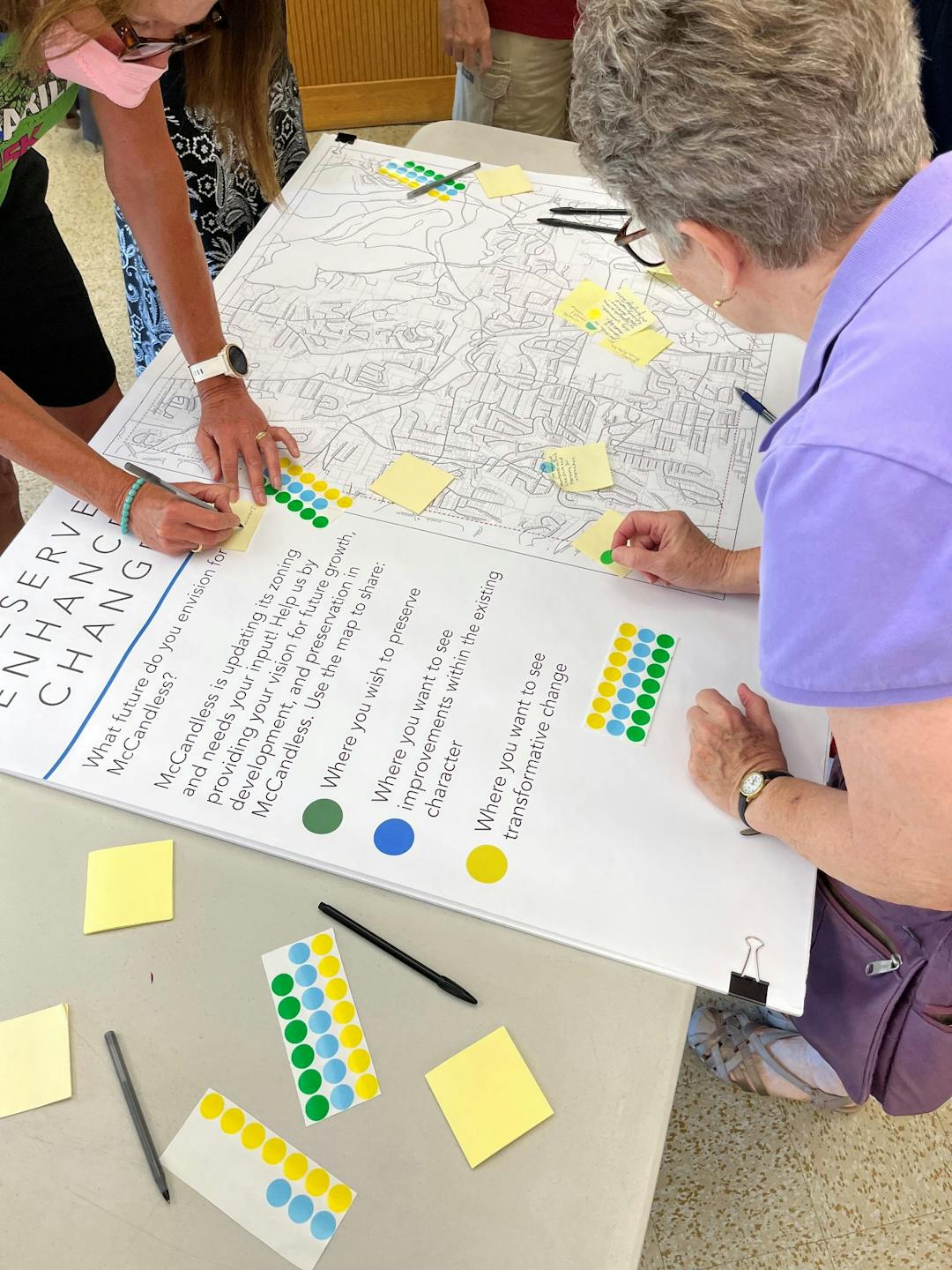 Attendees of the June 23 Open House making notes on a town map.