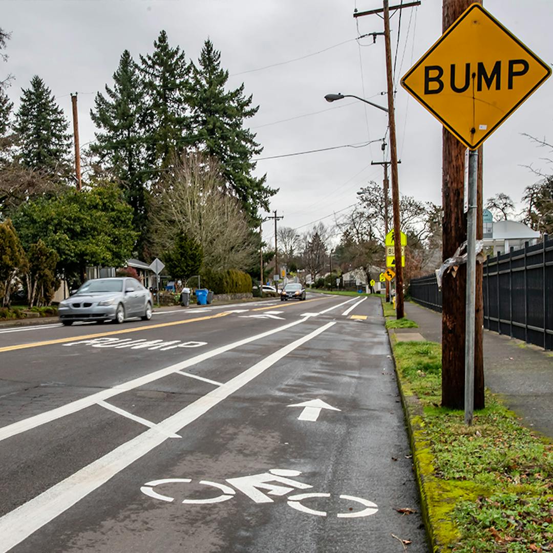 A section of McLoughlin Boulevard showing buffered bike lanes and speed cushions (bumps)