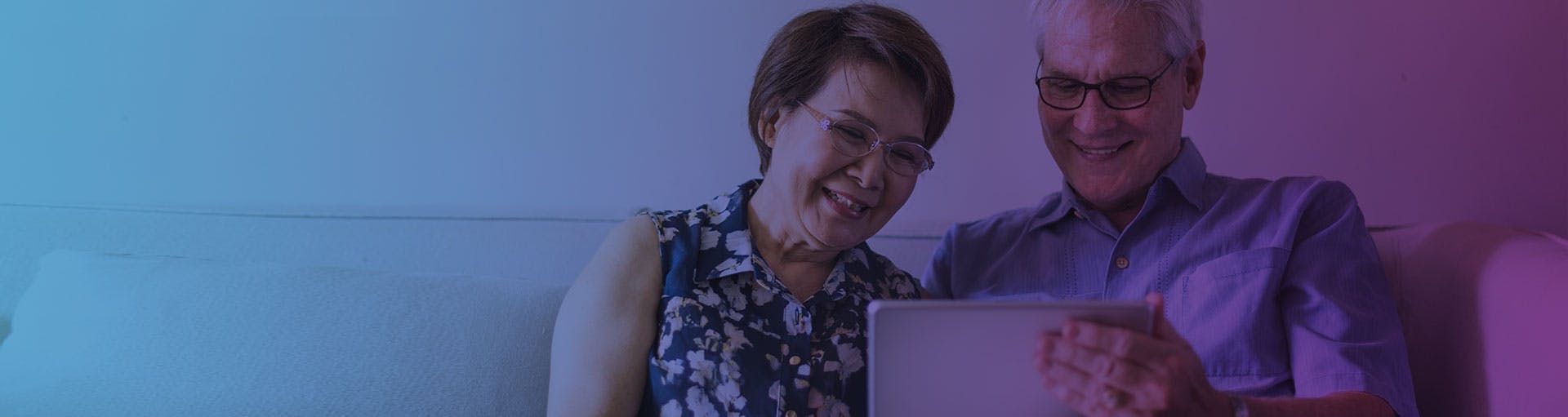 pink and purple gradient with a senior couple looking at a computer together