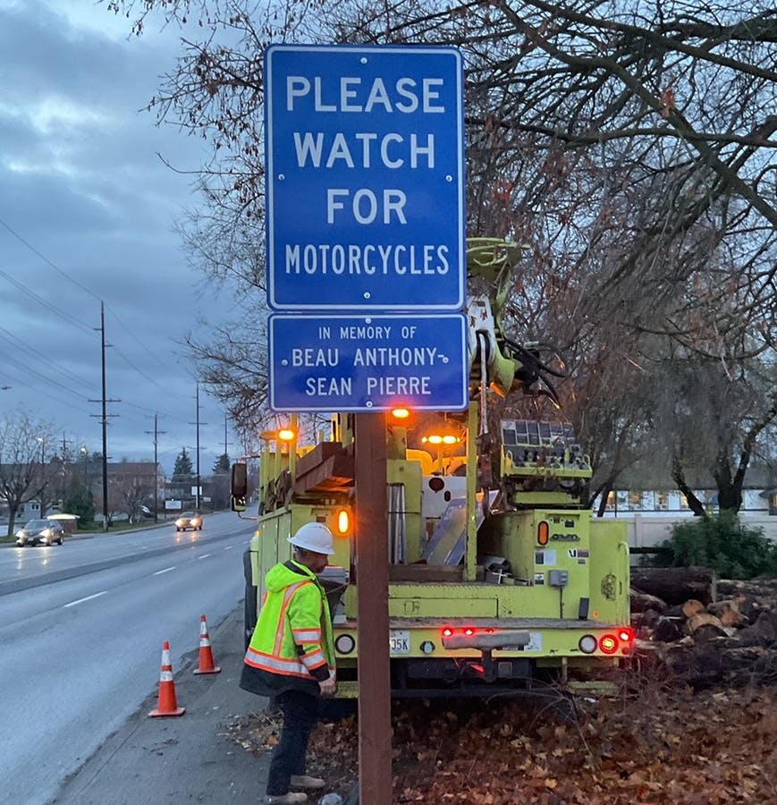 A "Please watch for motorcycles" sign being installed