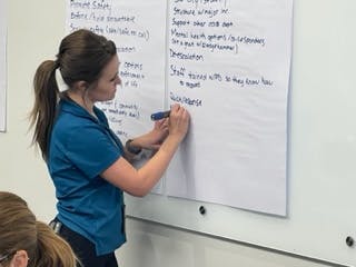 Facilitator writes group feedback on a whiteboard