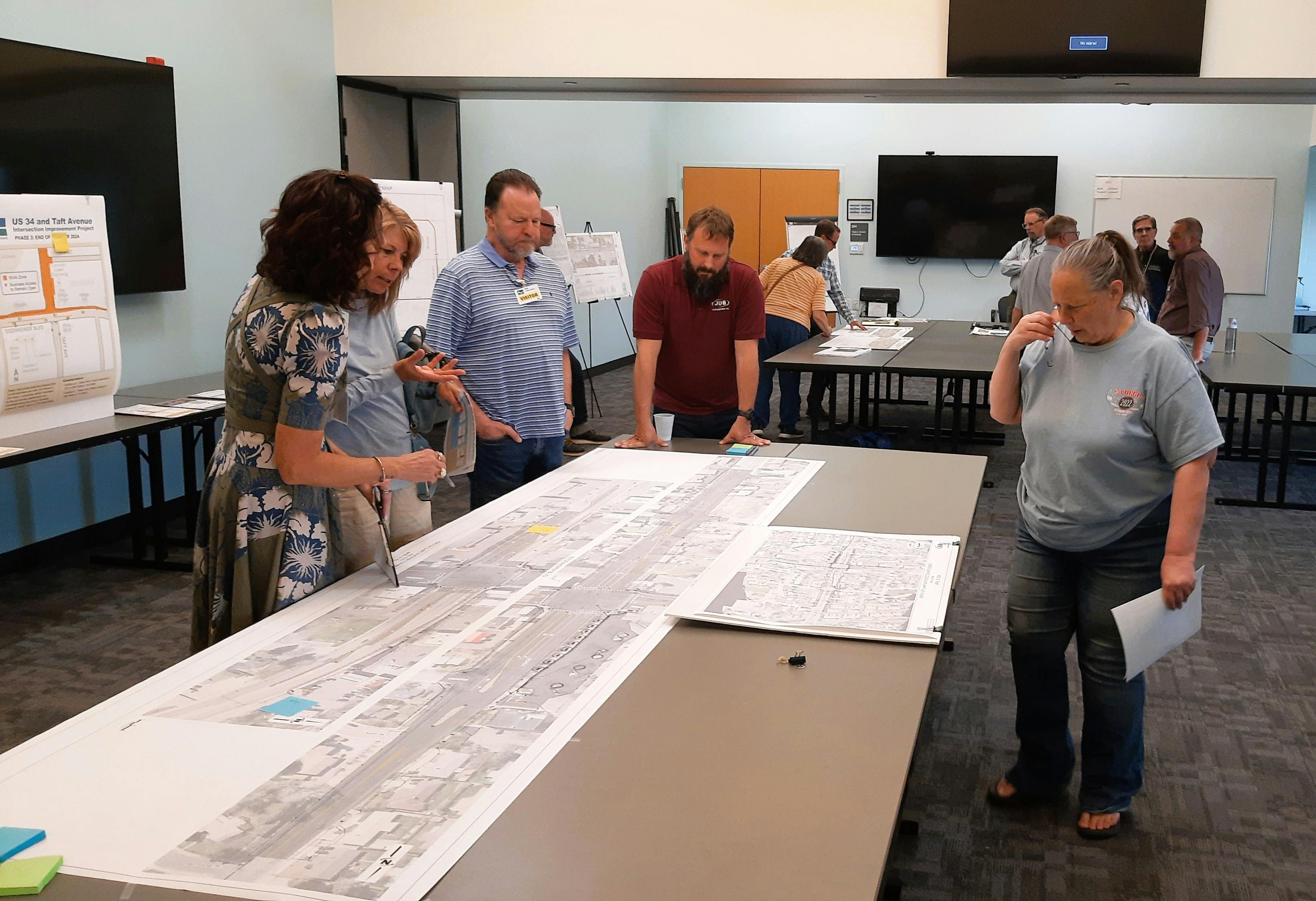 Residents surround a plot plan and discuss their questions with Acting Economic Development Director Marcie Willard. 