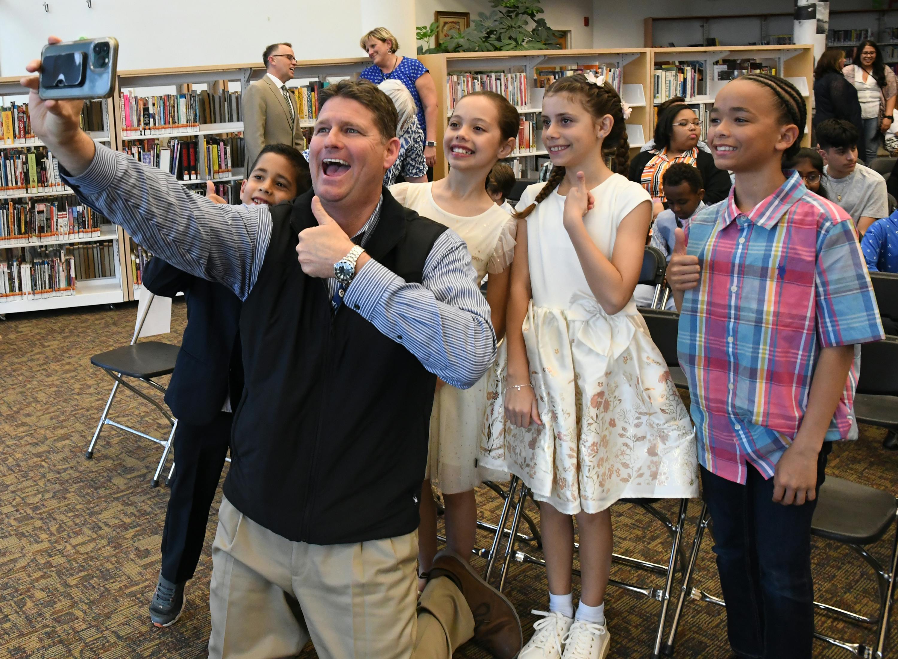 Students posing with their principal taking a picture at Aurora Scholars