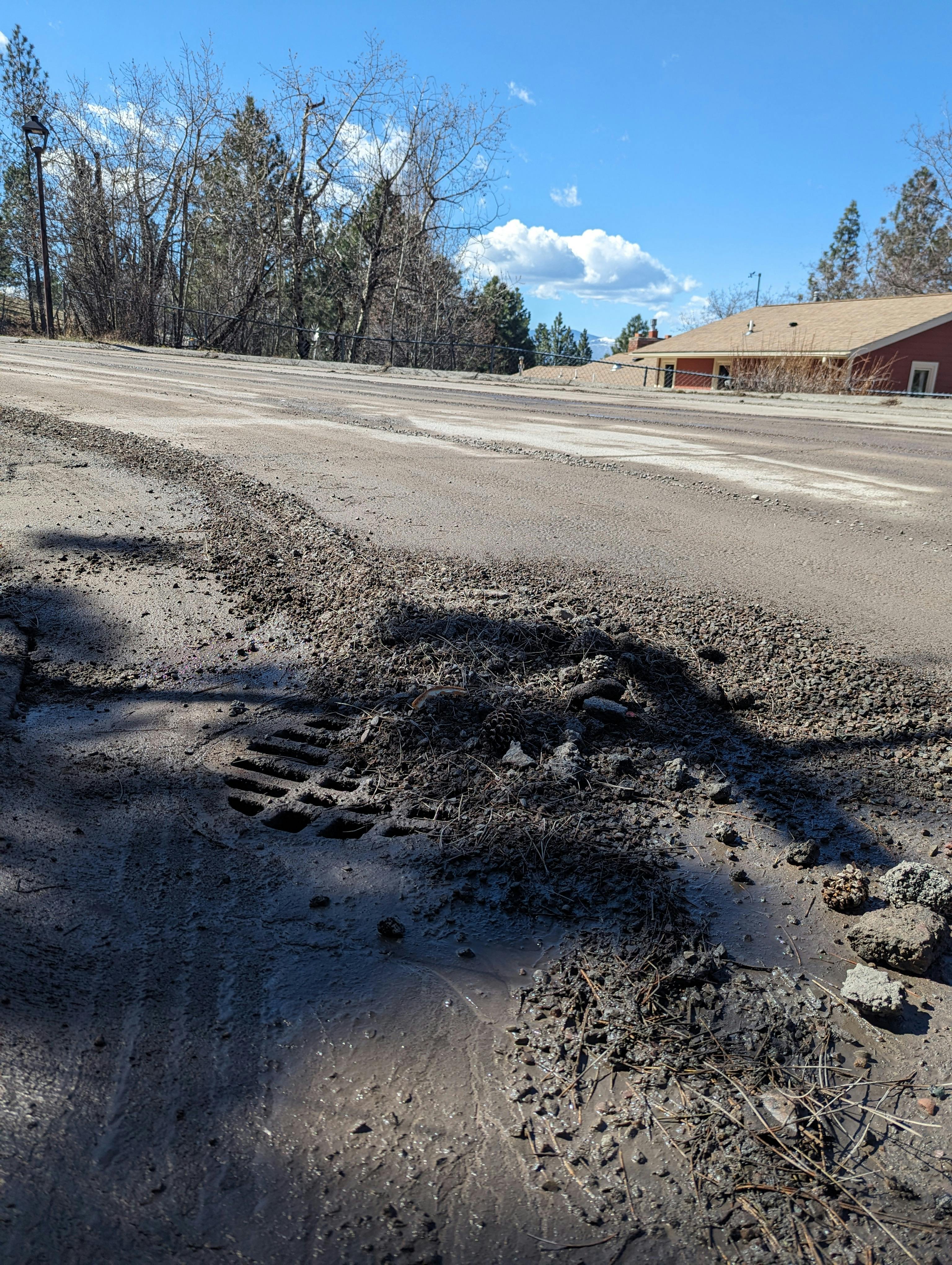 Image of a storm drain clogged with mud and debris.