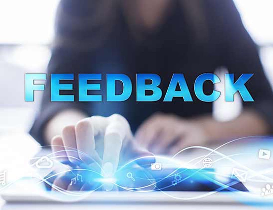 The word "feedback" in all capital, blue letters, which appear to be jumping off of a computer. 