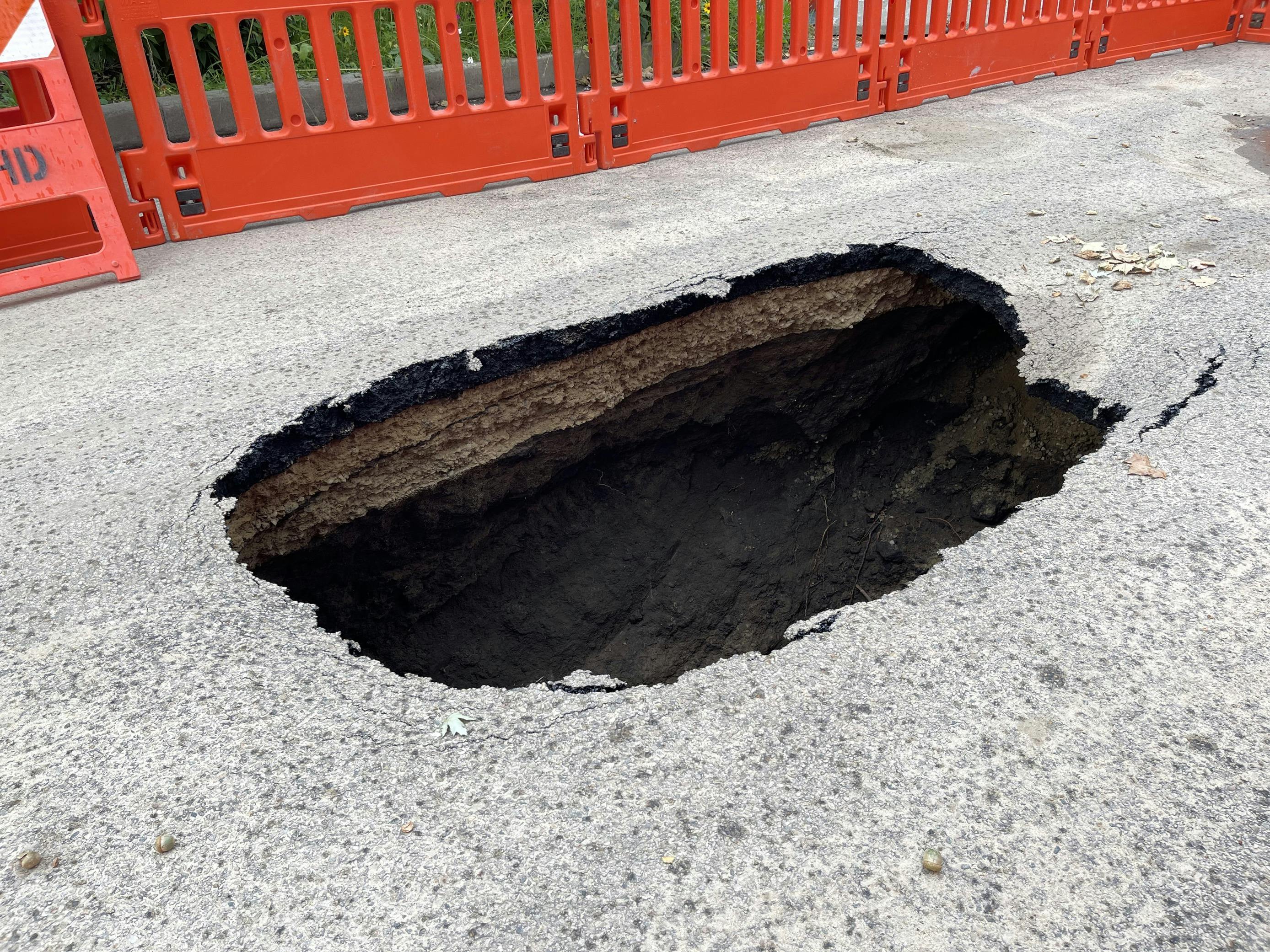 Sink hole shown with barricades in background on August 24