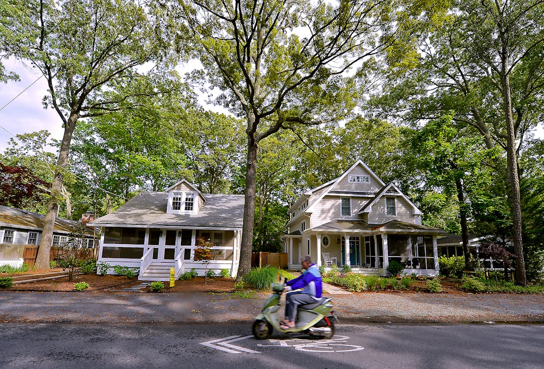 Scooter-rider driving by homes in Rehoboth Beach