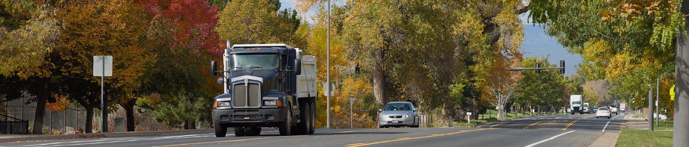 Ground level view of 1st Street with minimal traffic and fall leaves on the trees in the background.