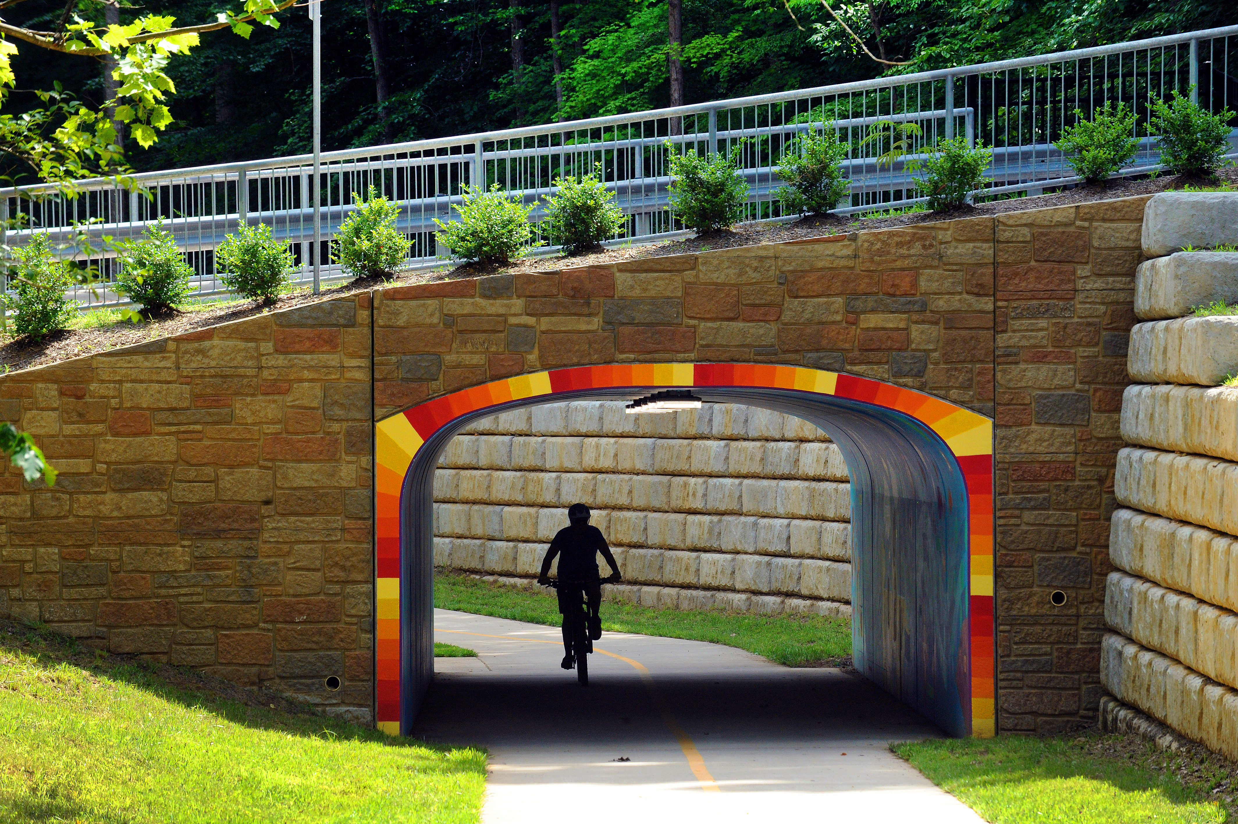 Person riding a bike through a greenway tunnel