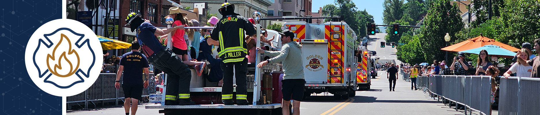 Fire personnel ride a fire truck down Washington Street during a parade.