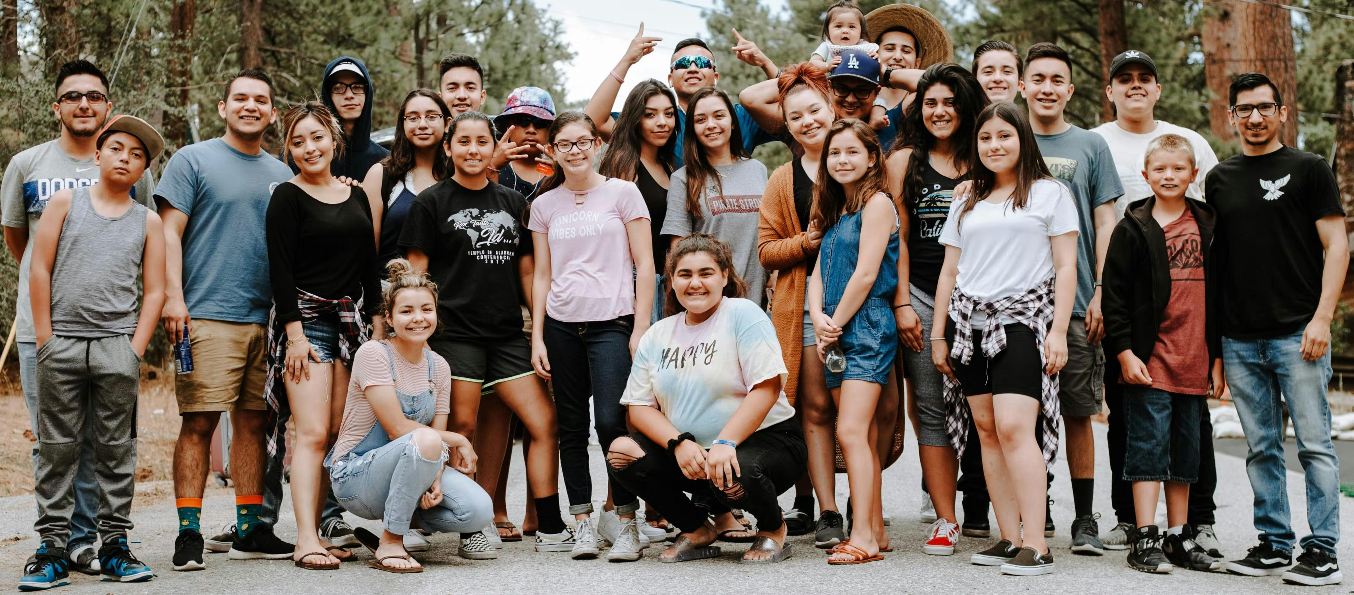 Group of young people smiling for a picture on a road