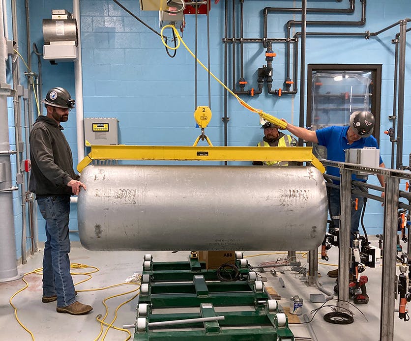 City of Columbia staff members lower an empty chlorine tank into position while testing the new jib crane in the Chemical Building.