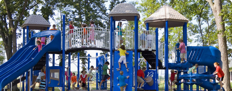 traditional playground features like large structure with towers, bridges, climbers, and slides