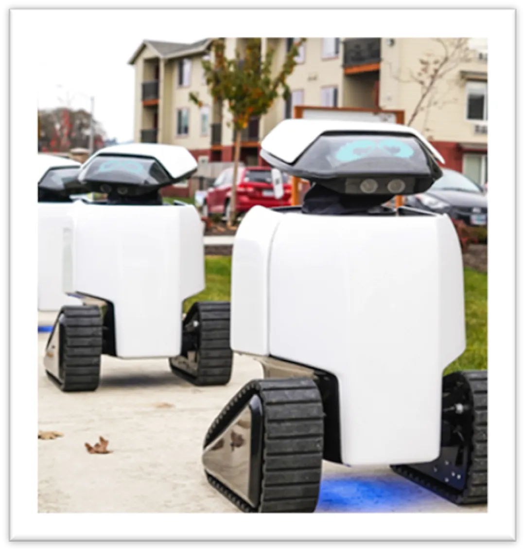 A white small robot with blue eyes is on a sidewalk with two similar robots following behind it. 