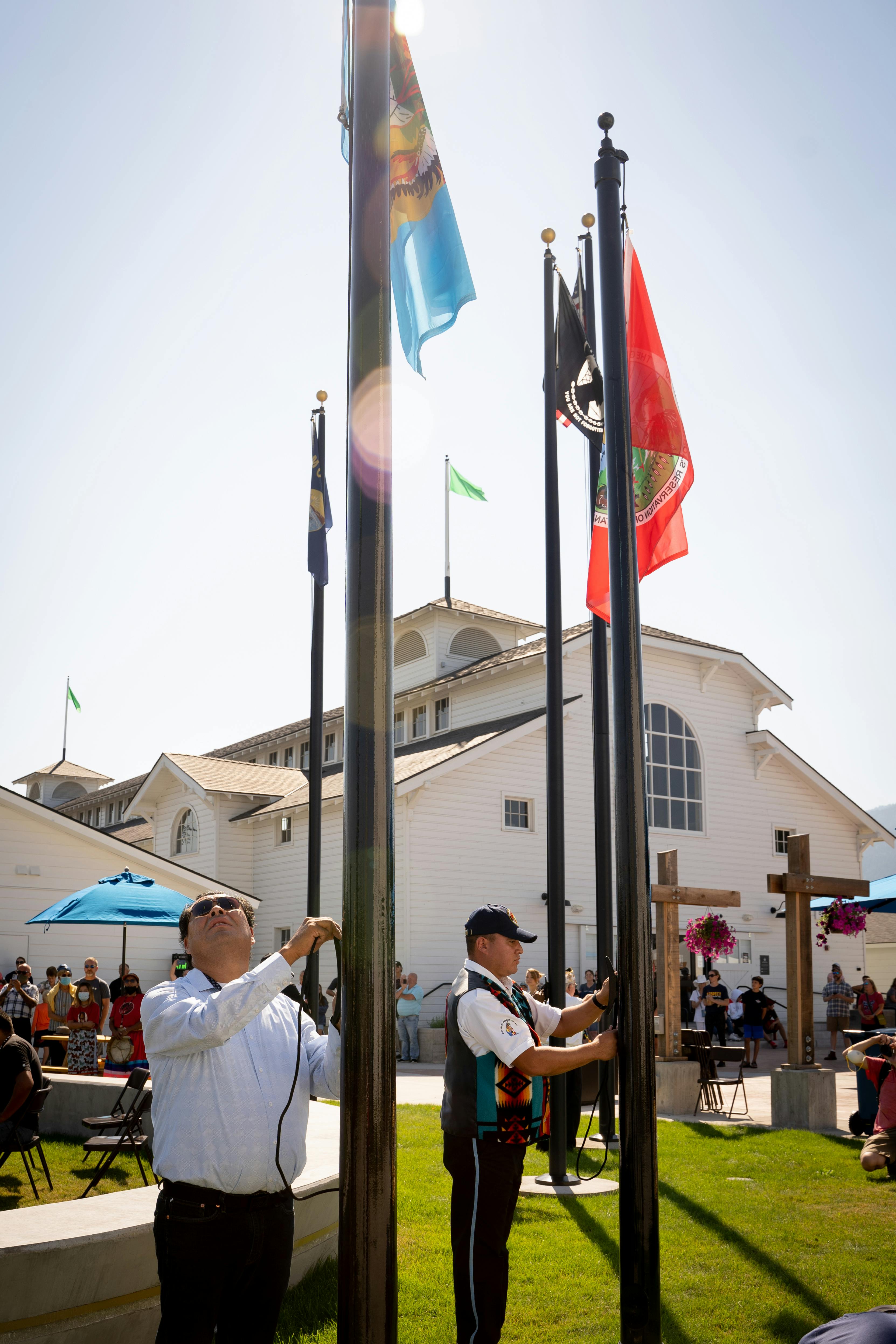 The different Tribal Nations raising their flags in the Historic Plaza on a sunny day at the Fair.