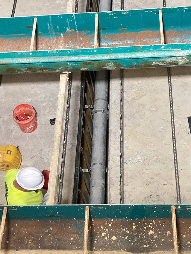 A worker double-checks the installation of a backwash pipe in Filter 6 in the Filter Building.