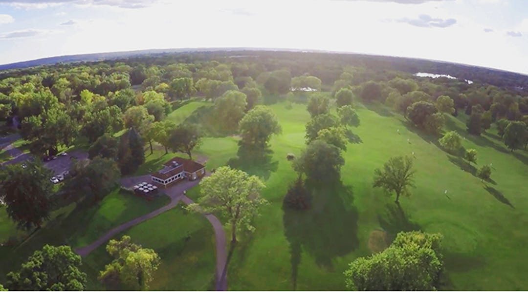 An aerial shot of Hyland Greens with clubhouse, driving range, and horizon.