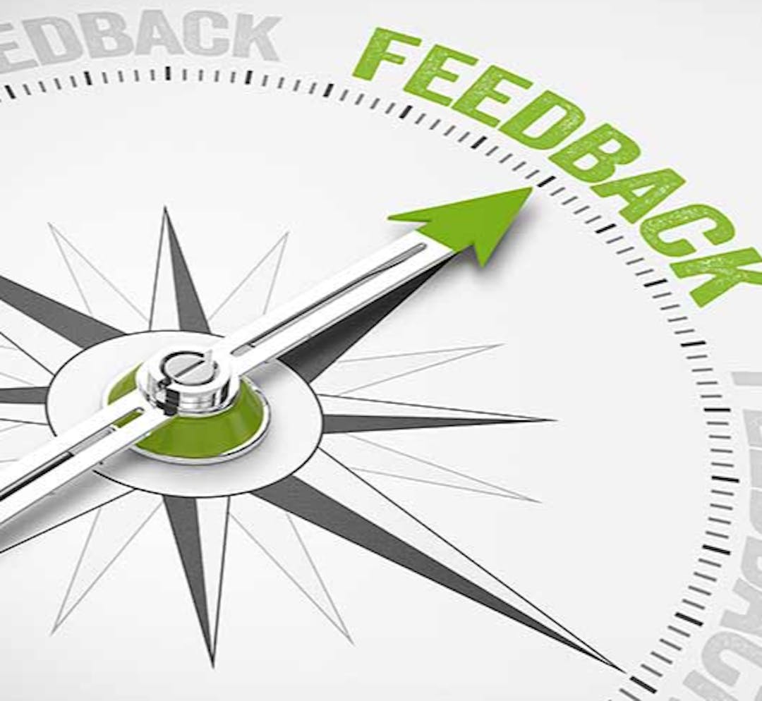 A green, white, and gray compass pointing to the word "feedback."