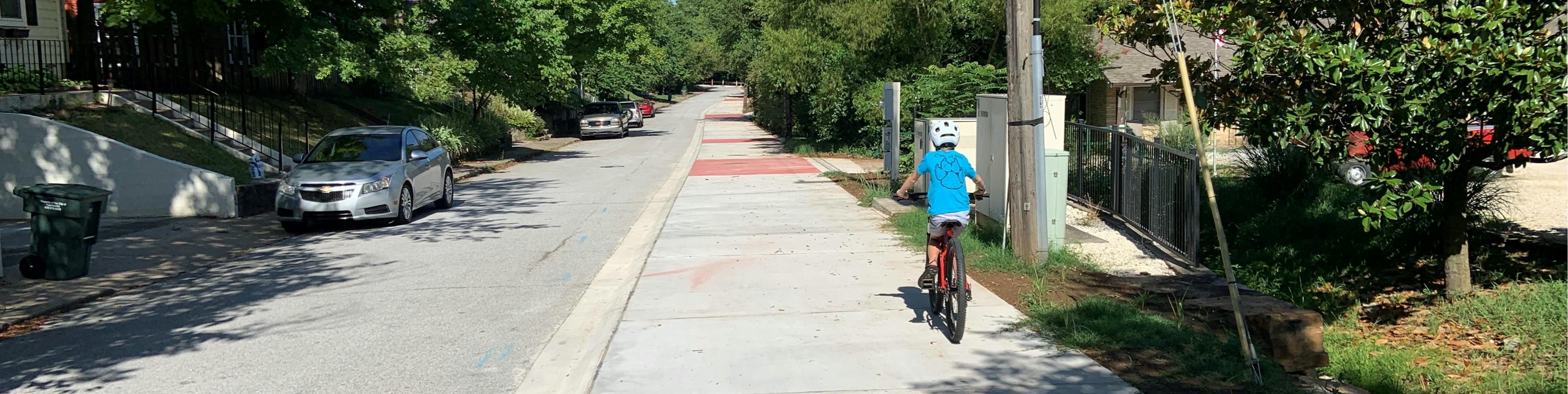 Cyclists riding down the Mission and Razorback Greenway trail connector