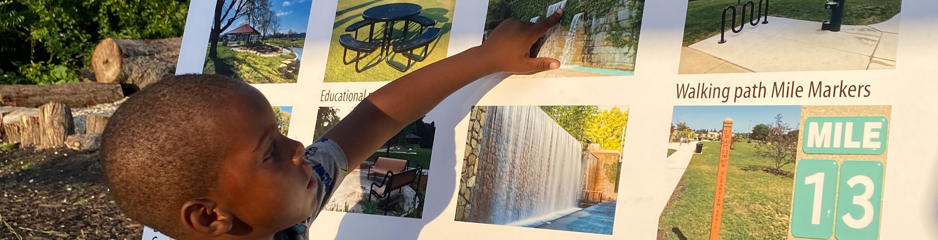 Child pointing to an idea board with photos of possible park amenities