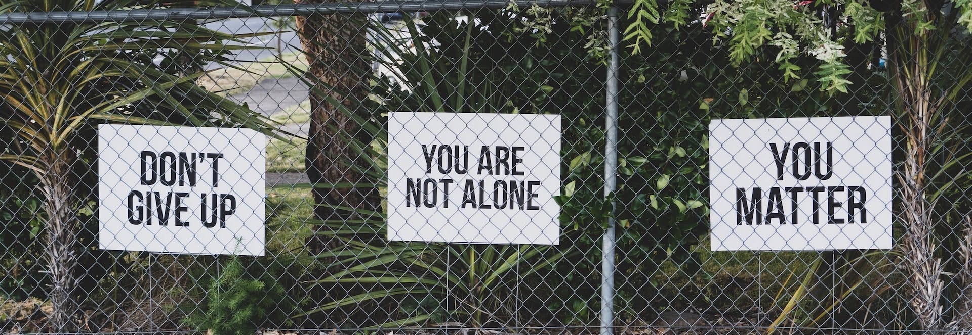 signs on fence - don't give up; you are not alone; you matter