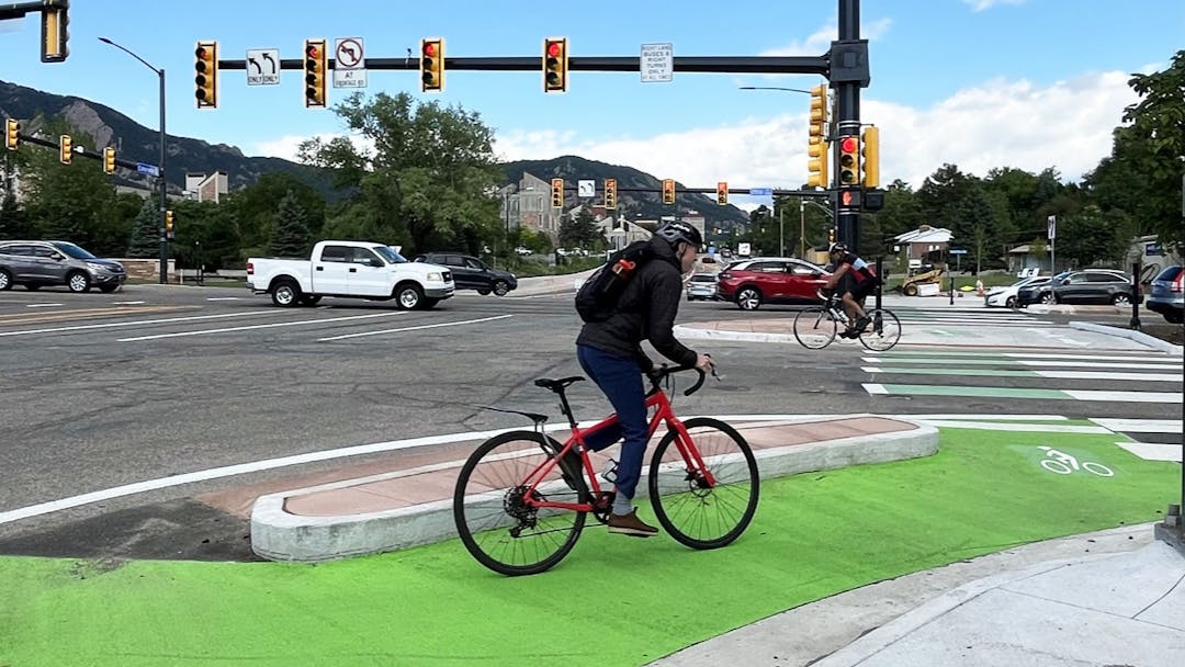 A bicyclist rides through the protected intersection at 28th Street and Colorado Avenue