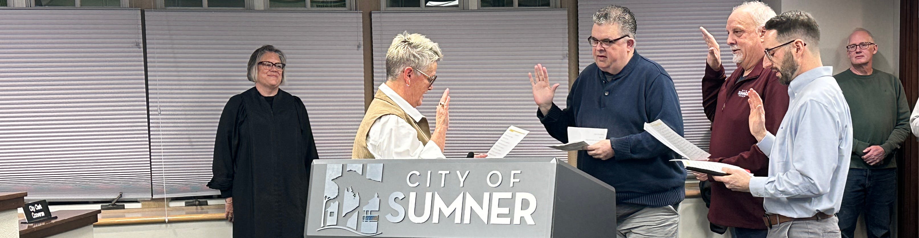 Image of Council sitting on the dais with video projection behind them. 