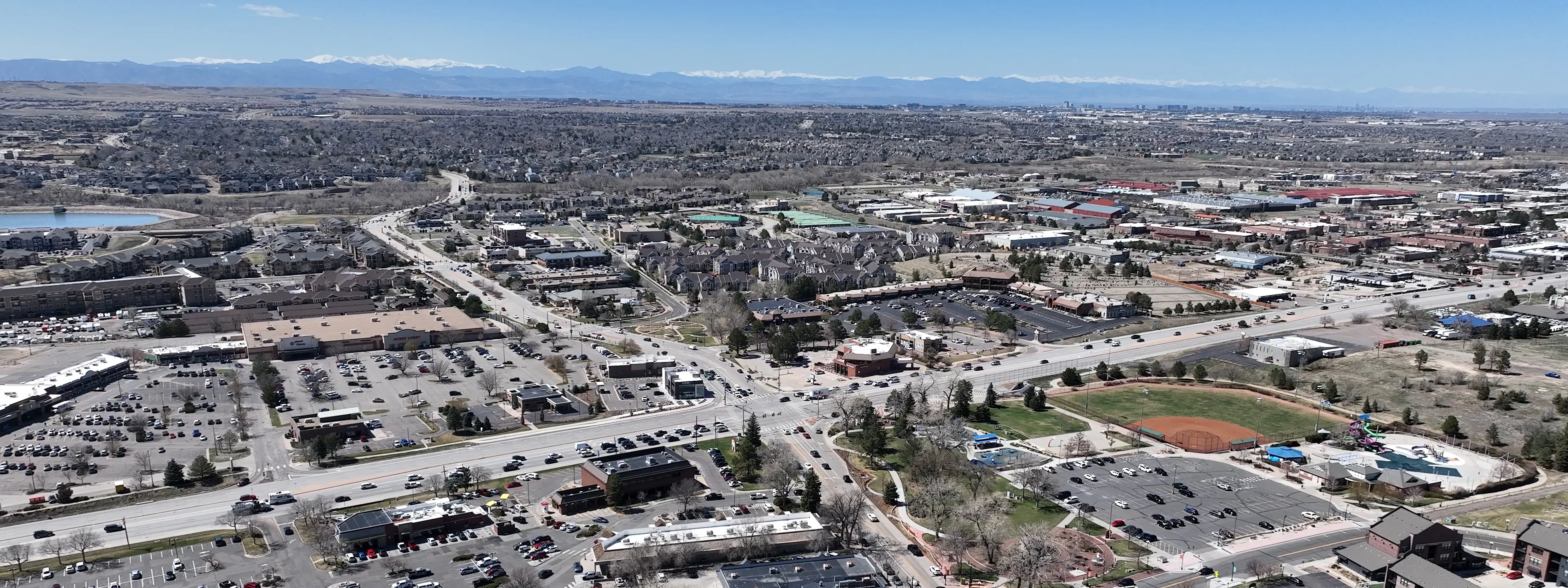 Aerial photo of the Parker Road and Mainstreet intersection and surrounding corridor with mountains in the background.