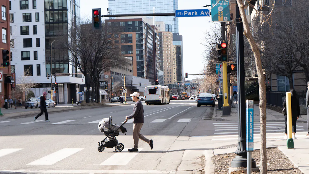 A street view of Washington Avenue and Park Avenue in downtown Minneapolis with people walking in crosswalks