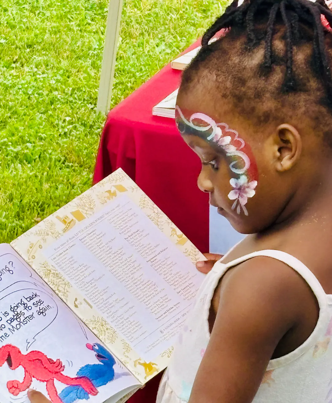 A girl reads a book at the 2025 Northview Heights Community Day.