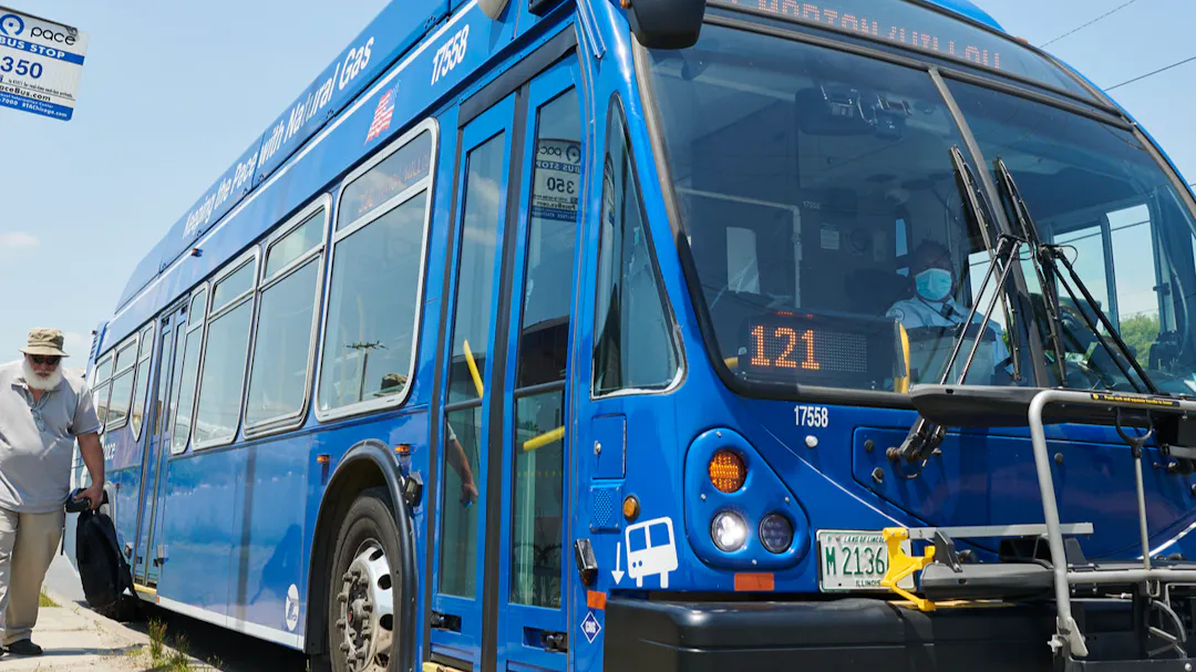 A man standing next to a Pace bus