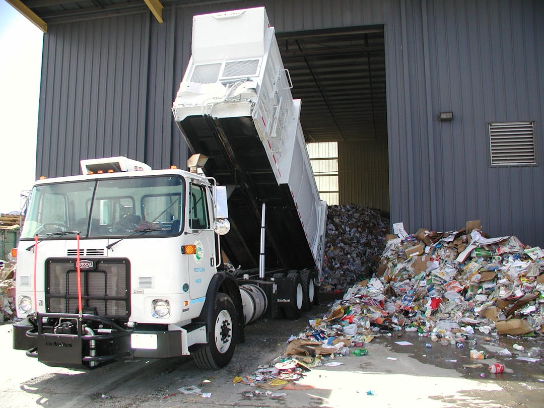 A City of Longmont recycling truck dumps recyclable material into a storage facility. 