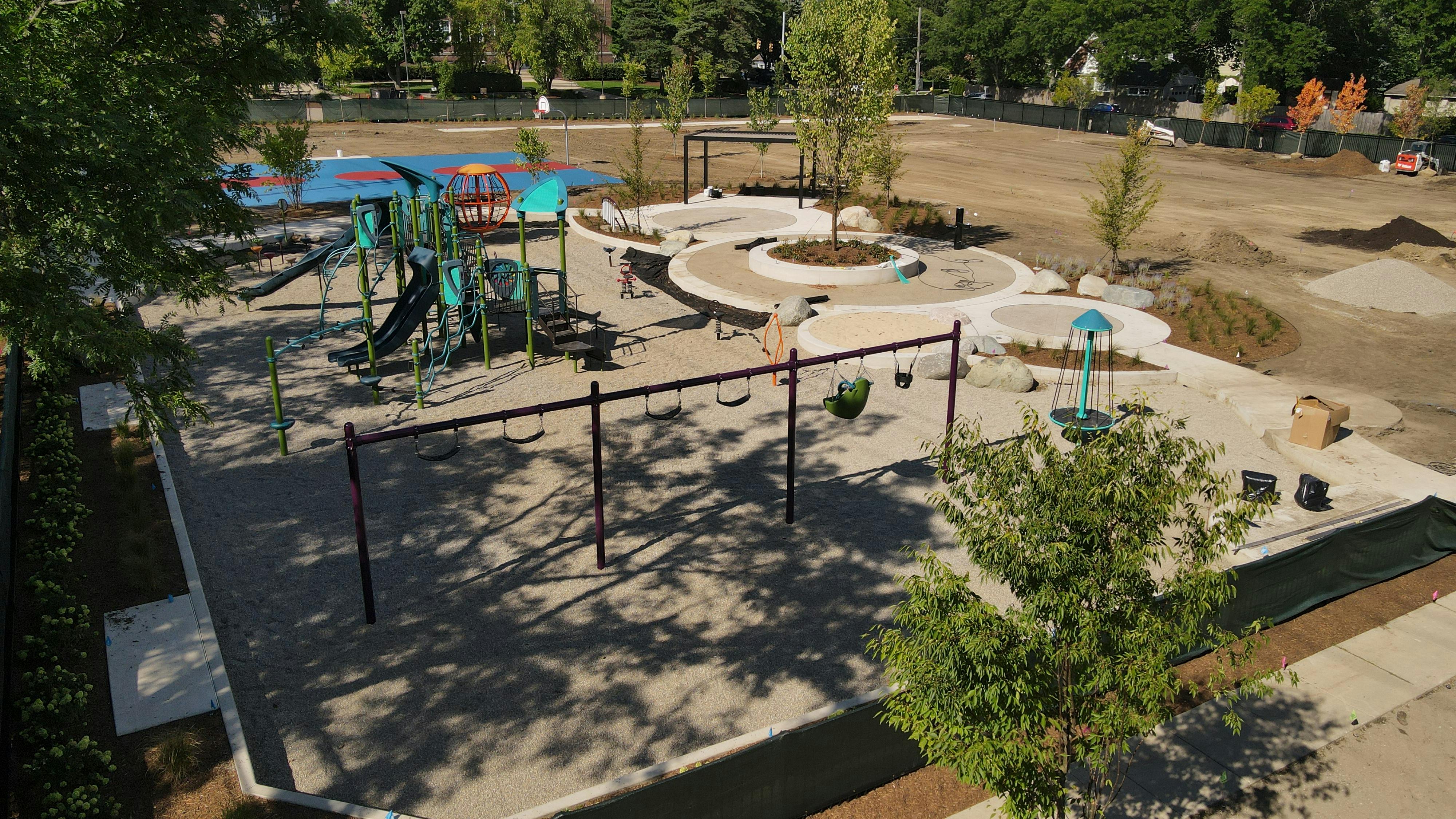 The playground equipment is installed and they are working on the base material.