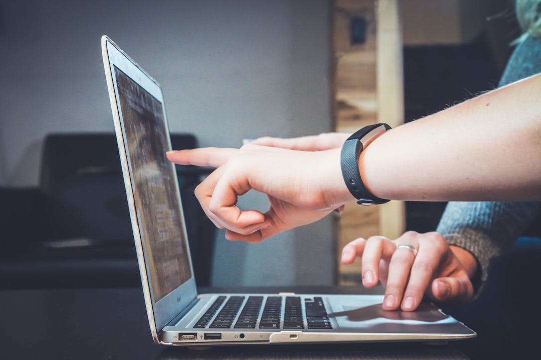 Person pointing and a laptop screen