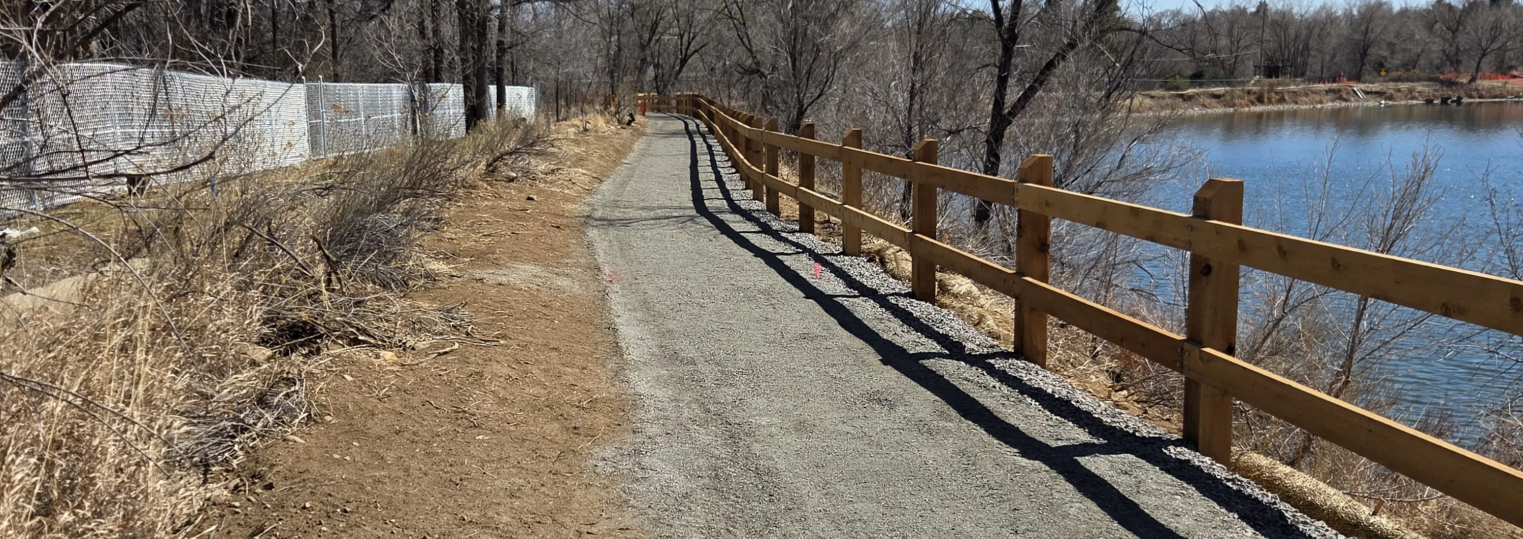 Soft surface trail along a lake with protective fencing